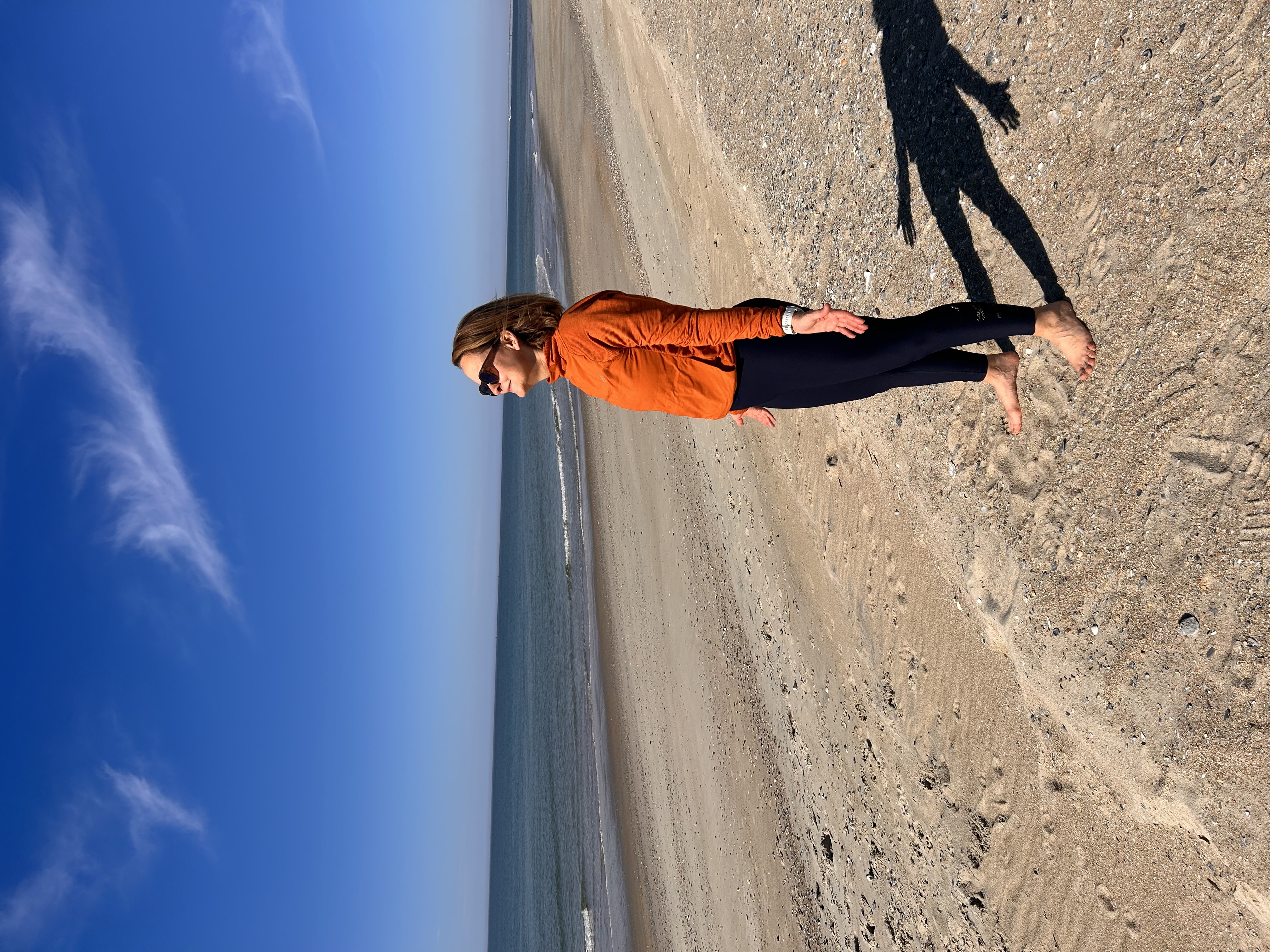Pure Alignment founder on the beach in warrior pose